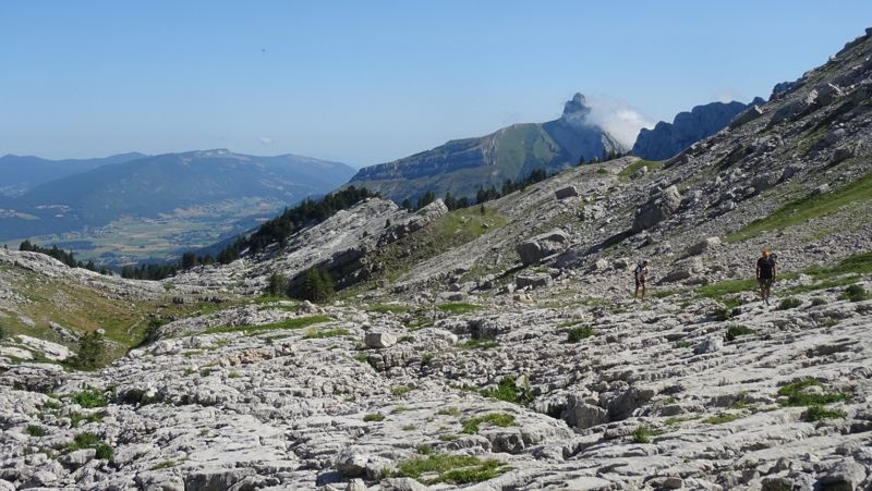 Randonneurs dans le lapiaz, sommets en arrière-plan