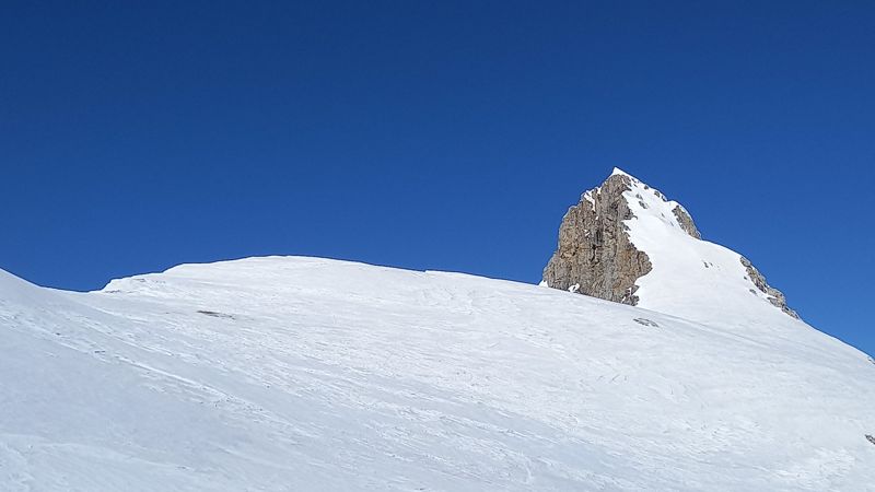 Aiguille rocheuse au-dessus d'une pente enneigée