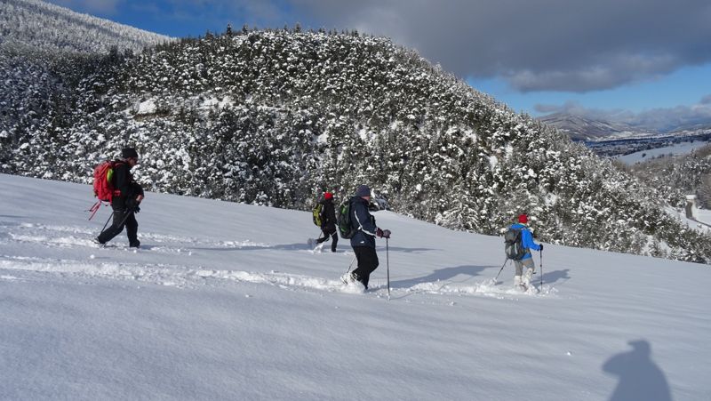 Raquettistes dans la poudreuse au-dessus de la vallée