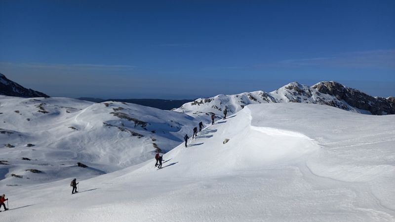 File de raquettistes sur une crête enneigée