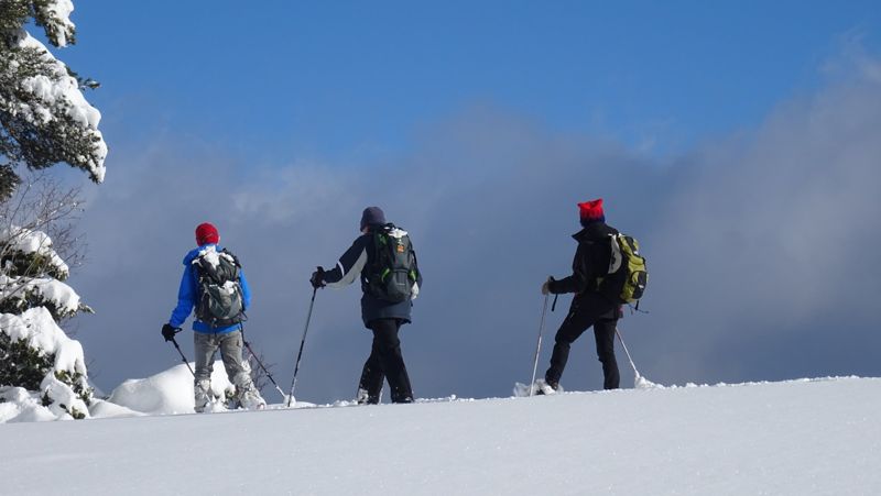 Trois raquettistes face aux nuages