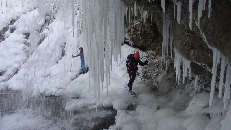 Raquettiste sous une cascade de glace